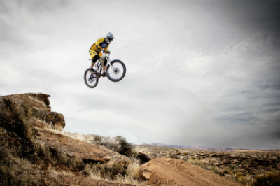Extreme biker jumping over sandy mountains