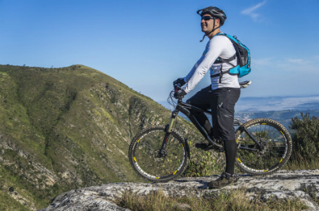 A man in the top of a mountain with his bike